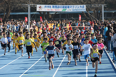 陸上競技場を元気よくスタートする小学生