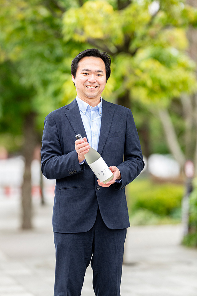 参加者に提供している日本酒「澤の泉」を持つ竹川隆司さん