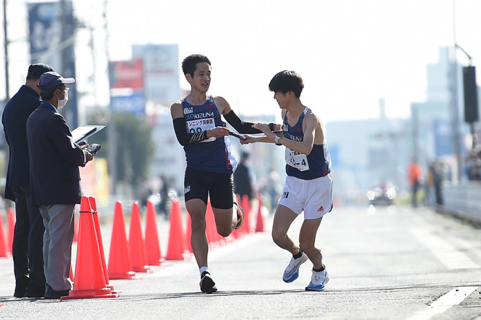 初出場の絆ランニング倶楽部・3区小田俊平選手（左）から4区菅沼蒼紫選手への襷渡し