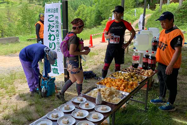 地産の冷奴やドーナツ、フルーツや漬物まで所狭しと並ぶ最終エイド「宮田高原」