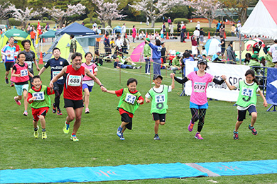 ラストの約500mを伴走してくれる地元の小学生、「応援KIDSランナー」と最後は笑顔でフィニッシュ！