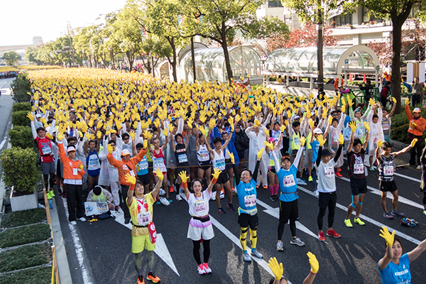 スタート前、神戸市の復興事業のシンボルフラワーに採用されたひまわりのように、ランナーが黄色い手袋をつけて手を高く掲げる