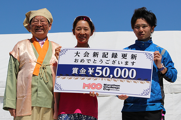 大会新記録で優勝した石井選手（右）と堤選手（中央）を、花咲か爺さんに扮した柴田町の町長が出迎えた
