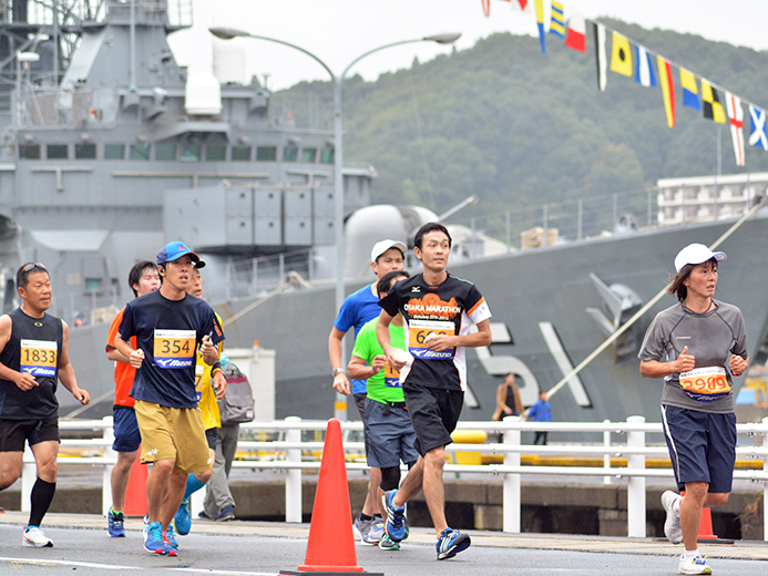 巨大な護衛艦などが停泊する舞鶴湾に臨むコースを走る