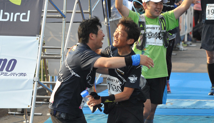 サロマ湖100kmのゴールシーンで喜び合うサロマチャレンジャーの吉田禎輔さん（左）といいのわたるコーチ（右）